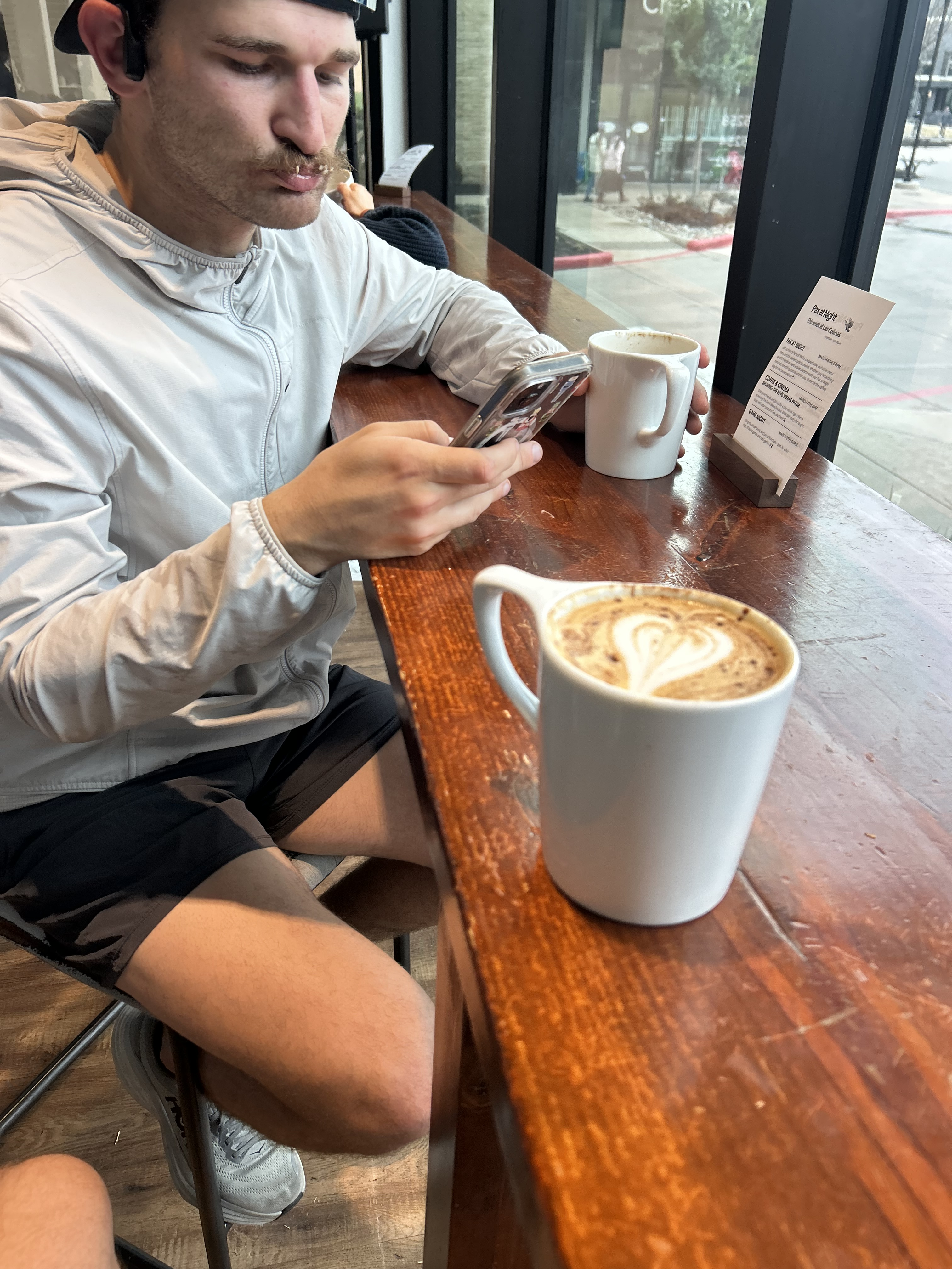 Jay Reilly sitting at a coffee shop with a latte